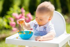 Cute Toddler With Messy Face Eating Lunch In Garden, Sitting In Royalty Free Stock Images