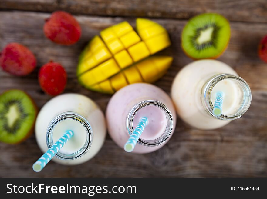 Smoothies with tropical fruits on a wooden background. Tasty breakfast. Healthy eating.