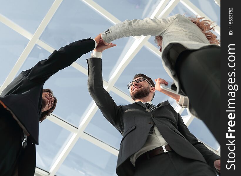 Happy business team giving high five in office. Happy business team giving high five in office