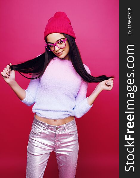 Young pretty teenage woman emotional posing on pink background, fashion lifestyle people concept close up