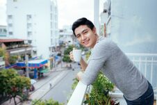 Handsome Guy Relaxing On A Balcony, On A City Backgroun Royalty Free Stock Images