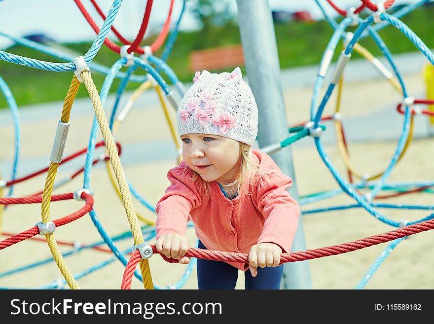 Active cute little girl on playground. child playing in summer outdoors. Active cute little girl on playground. child playing in summer outdoors