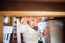Cute Toddler Boy Eating Sweets Under The Table. Royalty Free Stock Images