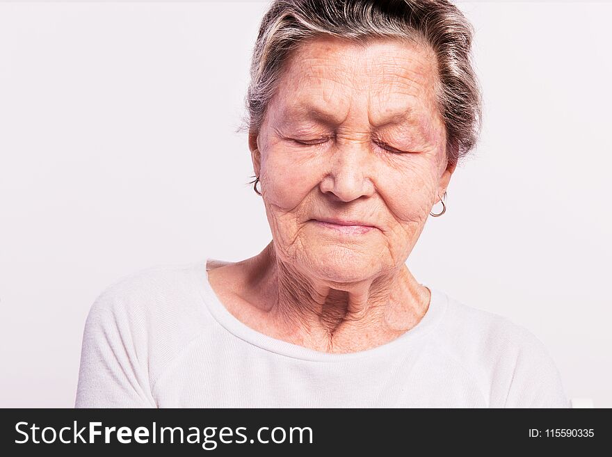 Portrait of a senior woman with closed eyes in a studio. Close up. Portrait of a senior woman with closed eyes in a studio. Close up.