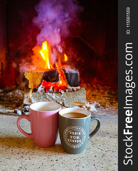 Bright colorful flame, burning wood at the fireplace, two coffee