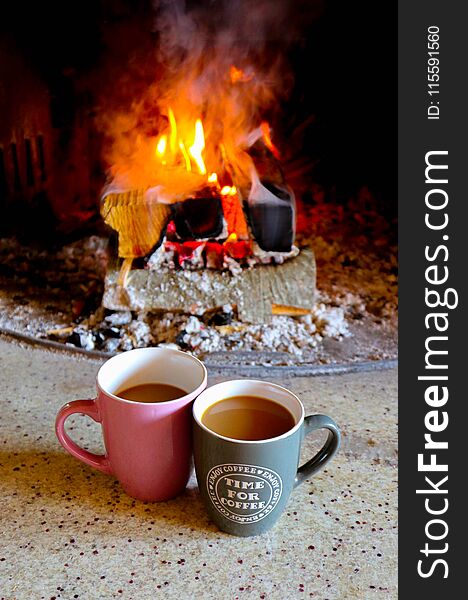 Bright colorful flame, burning wood at the fireplace, two coffee