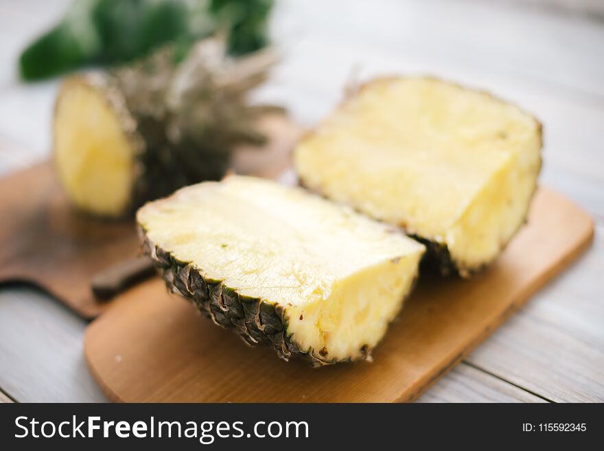 Sliced fresh pineapple on a wooden background in sunlight