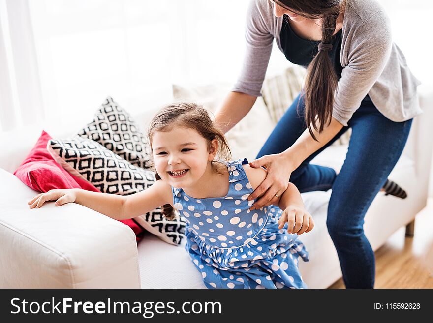 Young Mother With A Small Girl At Home.