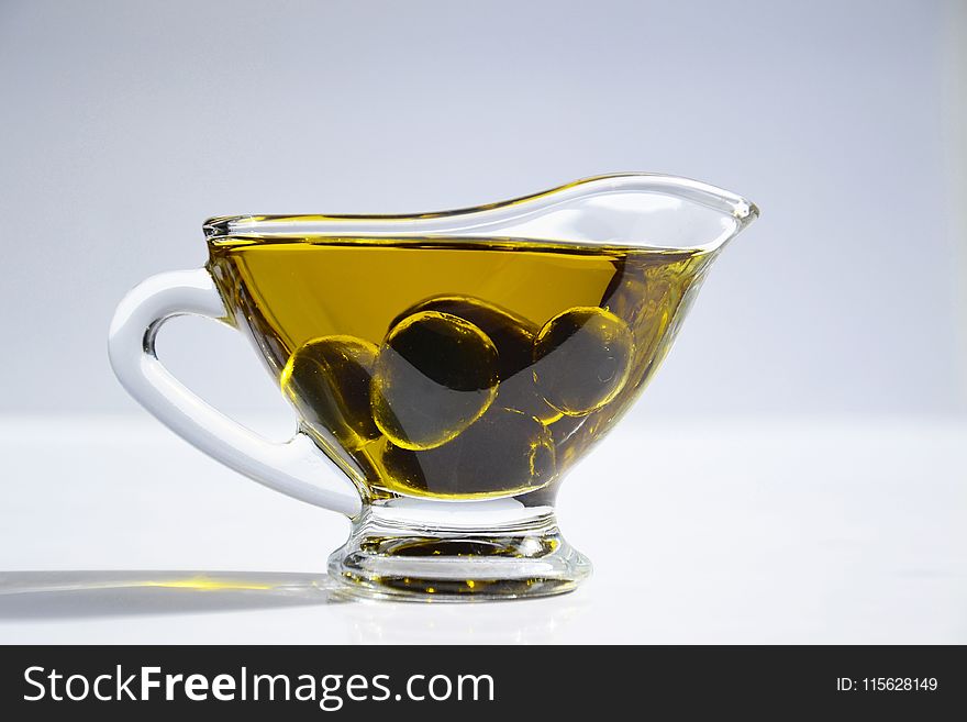 Photo of Olives on Cup of Olive Oil