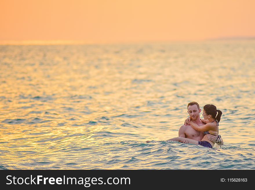 Man and Woman Swimming in a Beach