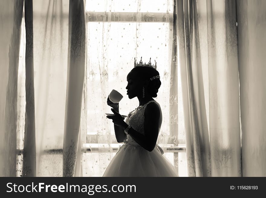 Woman in White Wedding Gown Holding Cup