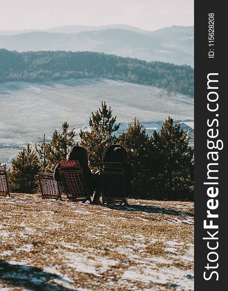 Photo of Two Woman Sitting on Folding Chair