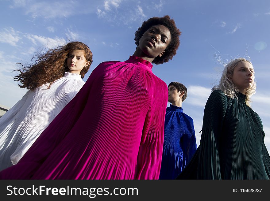 Low-angle Photography Of Four Women In Assorted-color Long-sleeved Turtle-neck Dresses