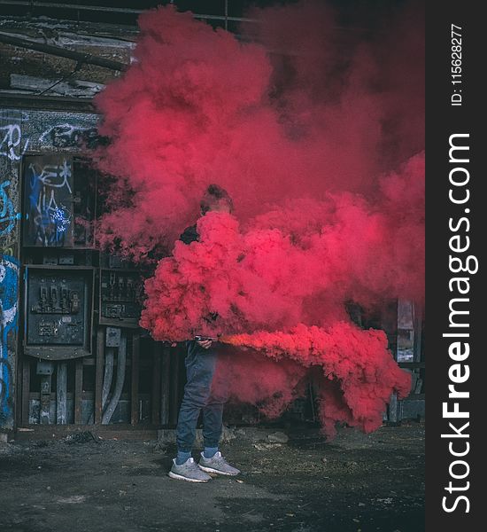 Photo of Man Surrounded by Red Smoke