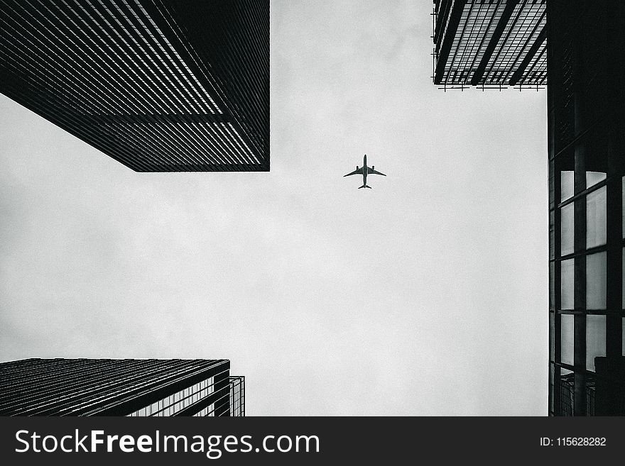 Low Angle Photography of Airplane And Buildings