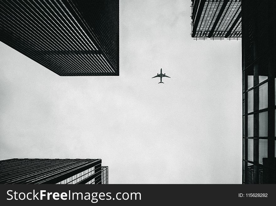 Low Angle Photography Of Airplane And Buildings