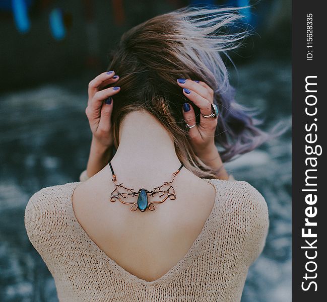 Woman Wears Gold-colored Blue Gemstone Pendant Necklace