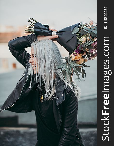 Woman Wearing Black Leather Jacket Holding Flower Bouquet