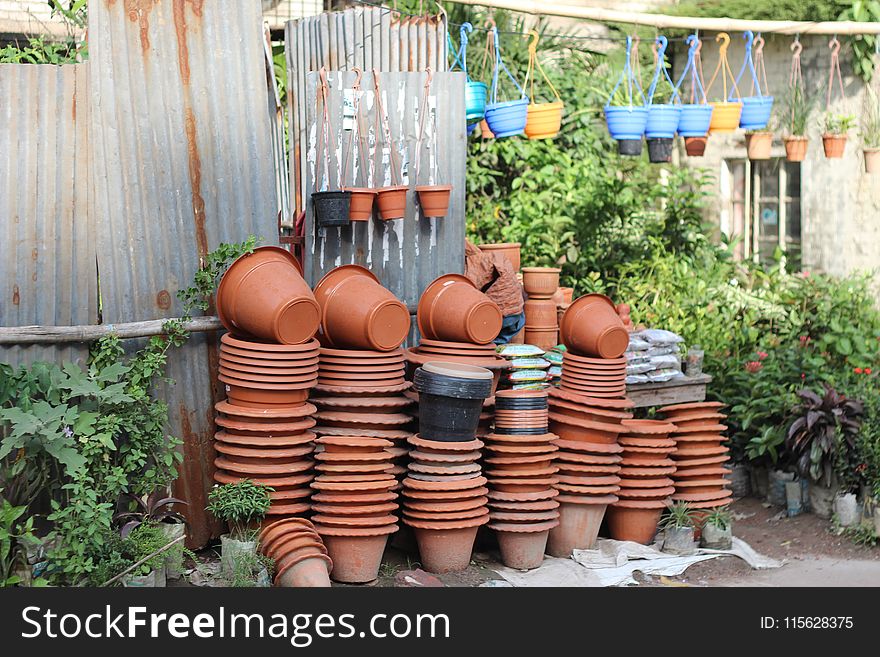 Stack of Clay Pots Beside Tin Roof