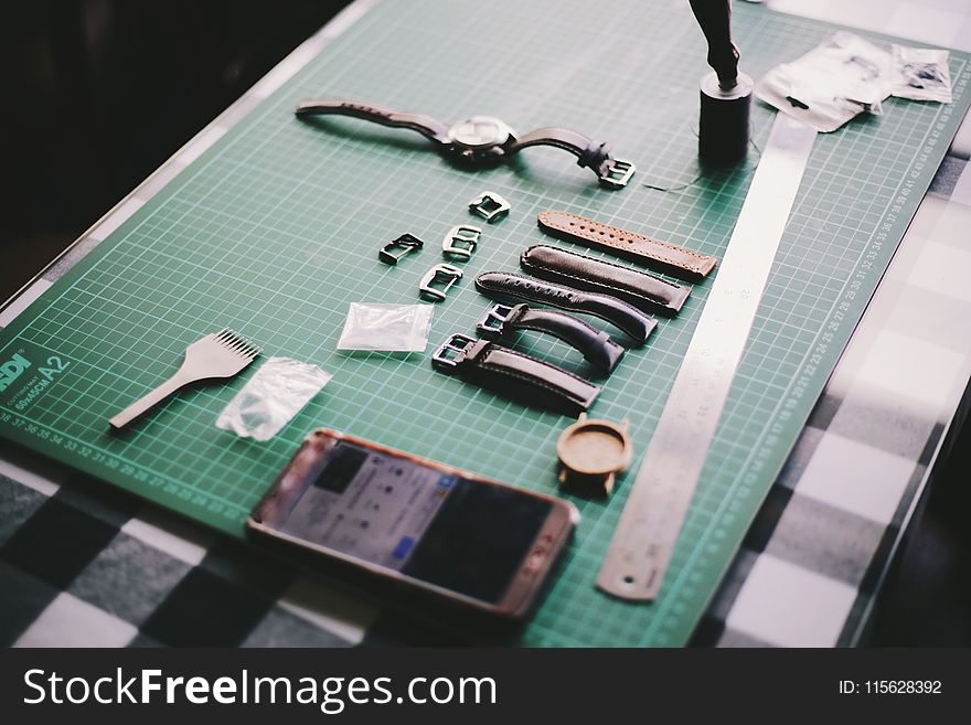 Watch With Straps Beside Smartphone On Table