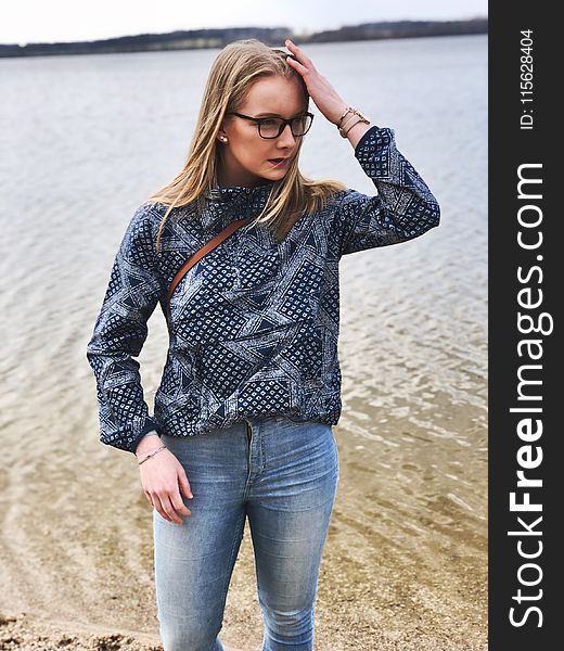 Woman in Blue and Gray Long-sleeved Shirt and Blue Denim Jeans Near Body of Water