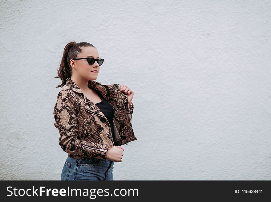 Photo of Woman Wearing Brown-and-black Snakeskin Jacket Beside Wall