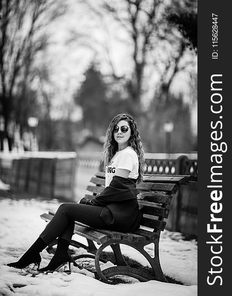 Grayscale Photography of Woman Sitting on Bench