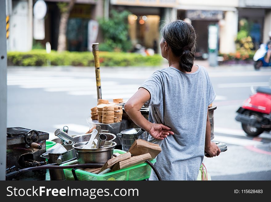 Woman Wearing Gray Shirt Standing Beside Food Cart