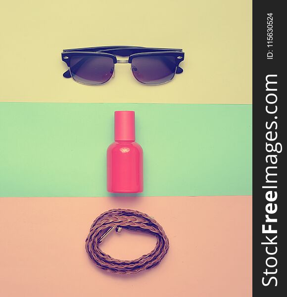 Women&#x27; s trendy accessories on a multicolored pastel background. Glasses, perfume, leather belt. Top view. Minimalism. Women&#x27; s trendy accessories on a multicolored pastel background. Glasses, perfume, leather belt. Top view. Minimalism.