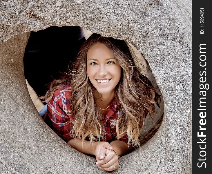 Woman Smiling Leaning On Stone Hole