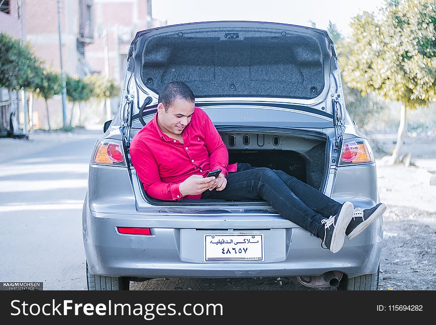 Man Seating on Car Trunk