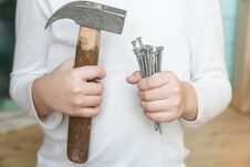 Child Holds A Hammer And Nails Stock Image