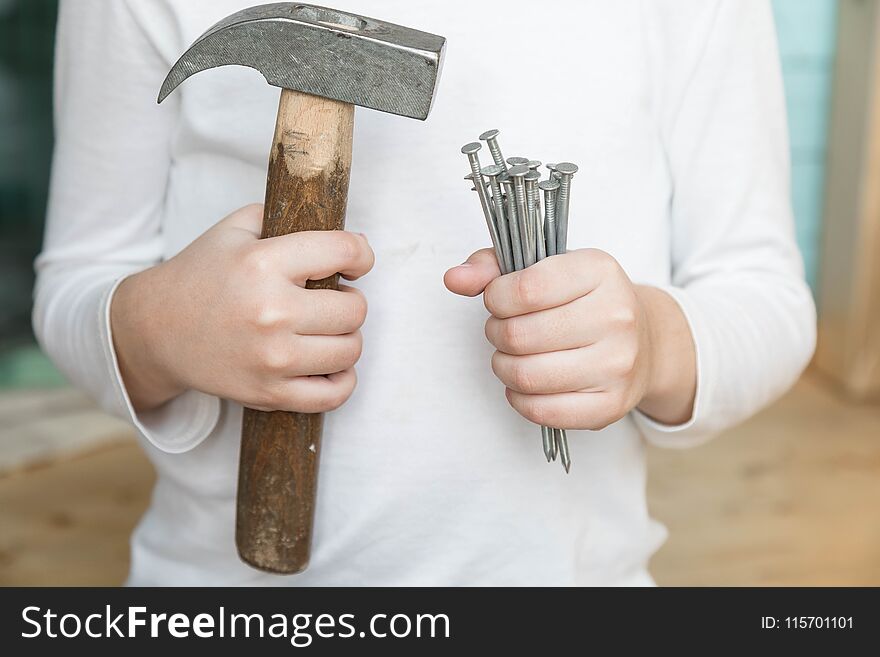 Child holds a hammer and nails