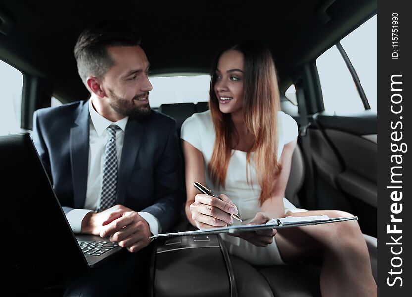 Beautiful women talking on phone and handsome men with laptop sitting on backseat in taxi car. Beautiful women talking on phone and handsome men with laptop sitting on backseat in taxi car