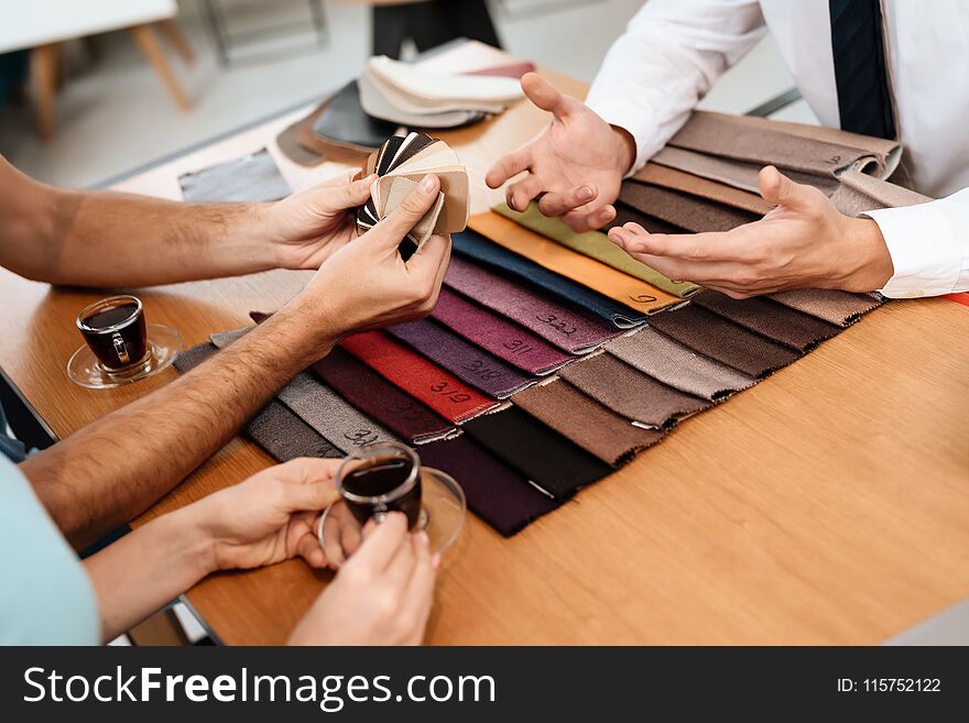 The seller shows samples of materials for furniture.