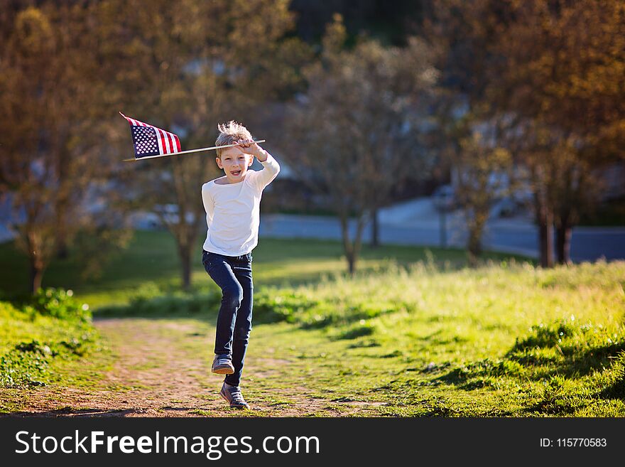 Positive little boy with american flag running and celebrating 4th of july, independence day, or memorial day. Positive little boy with american flag running and celebrating 4th of july, independence day, or memorial day