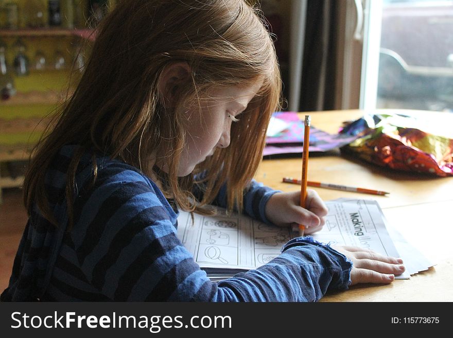 Girl Drawing On Brown Wooden Table