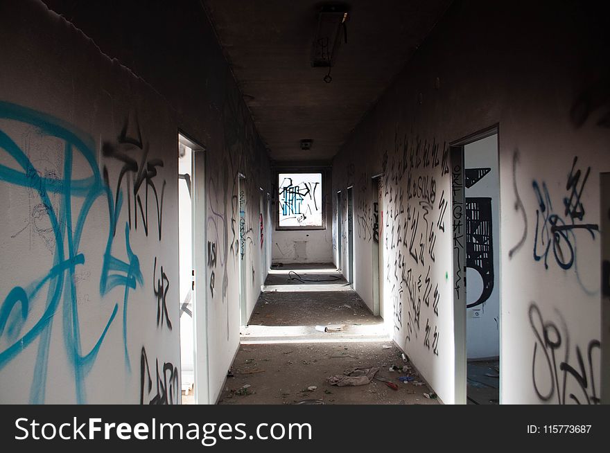 Empty Hallway With Black and Blue Graffiti