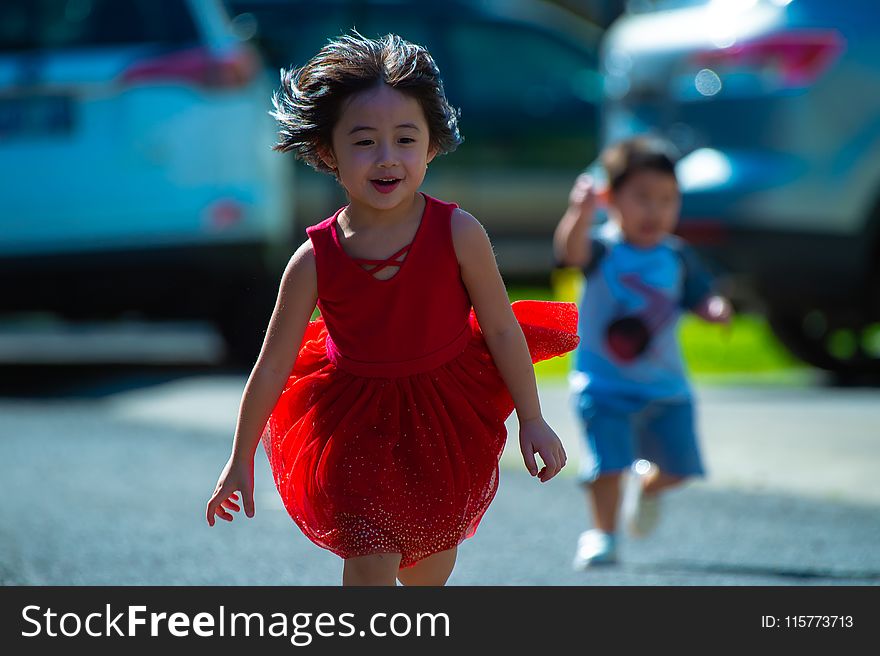 Photo of Girl in Red Dress Running on Street
