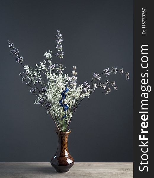 Shallow Focus Photography of White and Gray Flowers in Brown Ceramic Vase