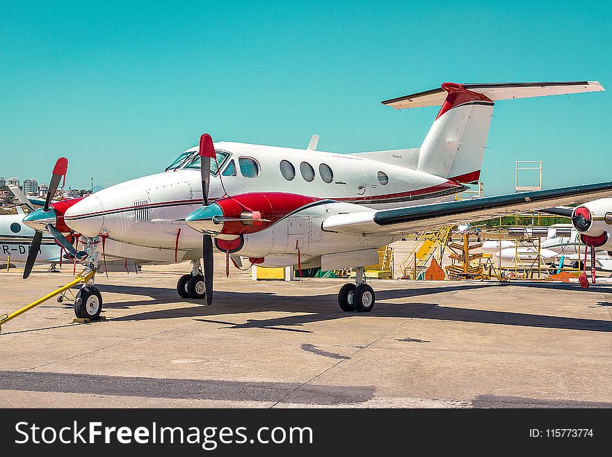 White And Red Plane Land