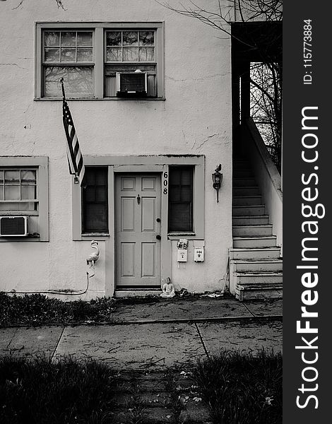 Grayscale Photo of Concrete House With Usa Flag