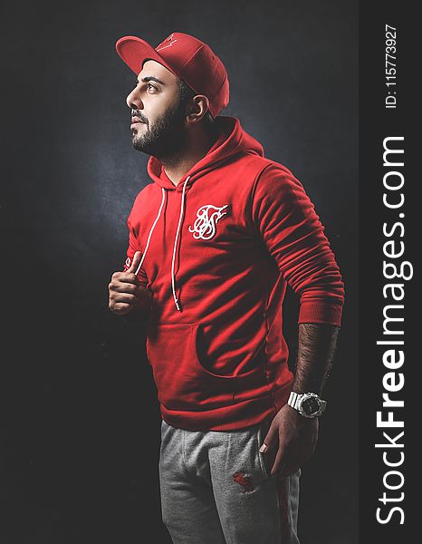 Man Wearing Red Pullover Hoodie and Gray Pants