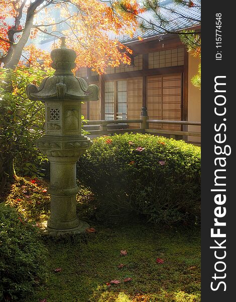 Sun beams over stone pagoda lantern by the pavilion at Japanese Garden during fall season. Sun beams over stone pagoda lantern by the pavilion at Japanese Garden during fall season