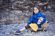 A Girl Sitting On Skateboard And Holding Toy Ship. Royalty Free Stock Images A Girl Sitting On Skateboard And Holding Toy Ship. Royalty Free Stock Images