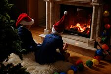 Two Cute Kids Sitting Near The Fireplace In Christmas Decorated Room. Royalty Free Stock Photography