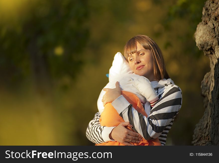 Selective Focus Photo Of Woman Carrying Baby