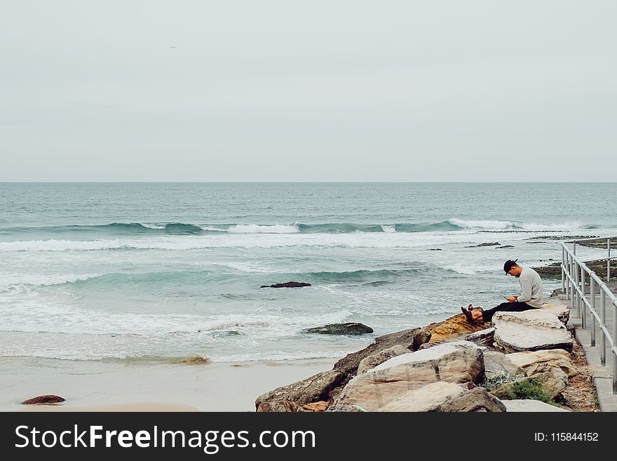 Man Sitting On Rocks