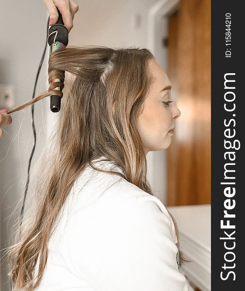 Woman Curling Her Hair