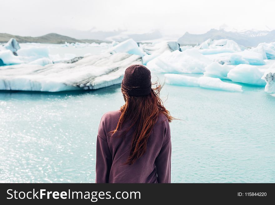 Woman Wearing Purple Shirt Overlooking at Body of Water and Snow Covered Field